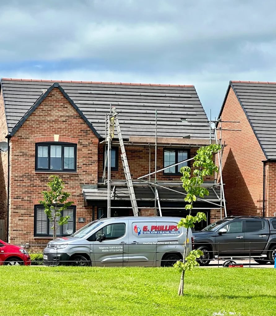 G Phillips van outside a house with scaffolding and solar panel rails being fitted